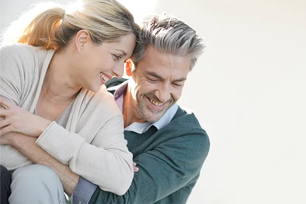 Health-and-Wellness-Services-Clinic A healthy middle-aged couple smile and embrace each other. Get services for your health issues from Julie Kane, NP of Bird Island Wellness in Calgary.
