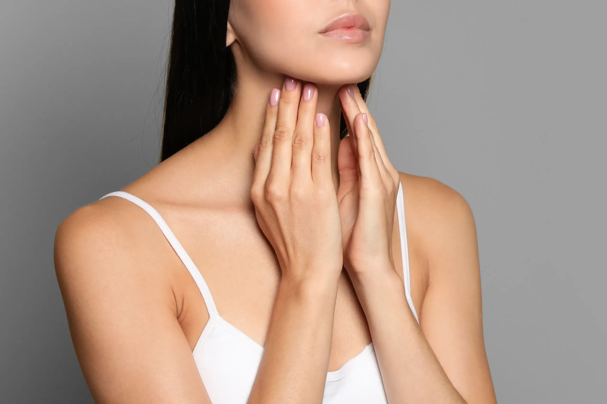 Thyroid-Doctor A woman in a white tank top touches her neck looking for signs of thyroid disorder. Get help for thyroid disorders from Julie Kane, NP of Bird Island Wellness in Calgary.